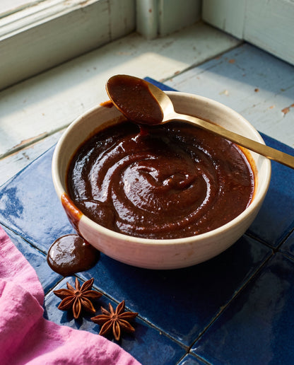 Close-up of Tamarind Heads Medium BBQ sauce in a bowl showing its thick glossy texture and star anise